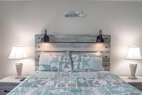 a bedroom with a large bed with two lamps at Surfrider Beach Getaway in Kure Beach