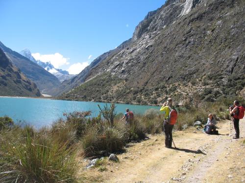 a group of people standing on a dirt road next to a lake at SANTA CRUZ TREKKING 4 DAYS from Vaqueria to Cashpampa purchase one night valued for 4 days trekking in Huaraz