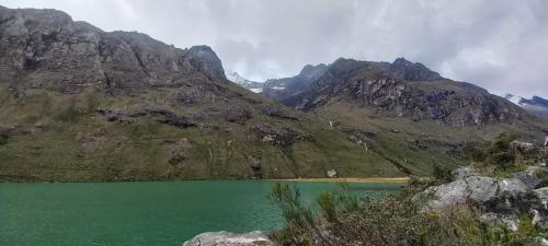 a green lake in the middle of a mountain at SANTA CRUZ TREKKING 4 DAYS from Vaqueria to Cashpampa purchase one night valued for 4 days trekking in Huaraz