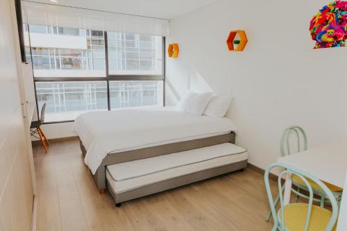 ein weißes Schlafzimmer mit einem Bett und einem Fenster in der Unterkunft Estudio en Usaquén cerca a la Fundación Santa Fe ! in Bogotá