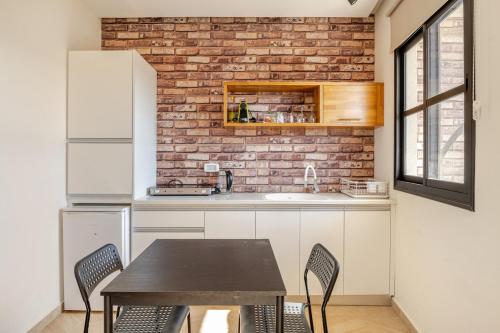 a kitchen with a table and a brick wall at Villa for families with a private pool in Daliyat El Carmel in Dāliyat el Karmil