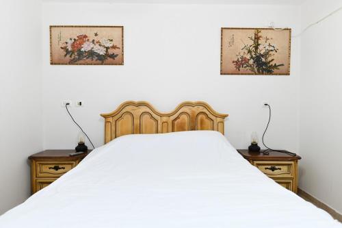 a bedroom with a white bed and two night stands at Villa for families with a private pool in Daliyat El Carmel in Dāliyat el Karmil