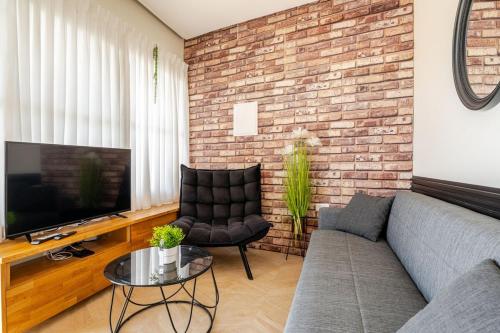 a living room with a couch and a brick wall at Villa for families with a private pool in Daliyat El Carmel in Dāliyat el Karmil