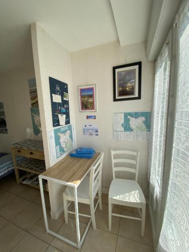 une salle à manger avec une table et deux chaises dans l'établissement Entre Roches et Marées, à Montfarville