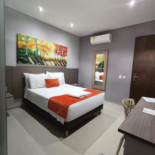 a bedroom with a bed and a painting on the wall at Hotel Santa Clara Boutique in Montería