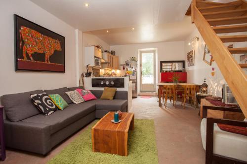 un salon avec un canapé et une table dans l'établissement Maison dans un coin de verdure proche de la Sorgue, à LʼIsle-sur-la-Sorgue