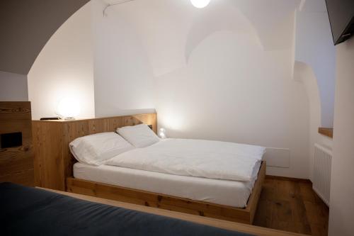 a bedroom with a bed with white sheets at La Stua in Vermiglio