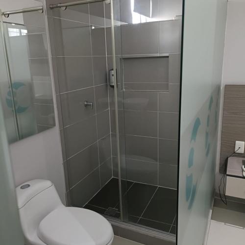 a bathroom with a toilet and a glass shower at Hotel Santa Clara Boutique in Montería