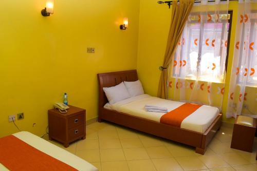 a small bedroom with two beds and a window at new raya hotel in Nairobi