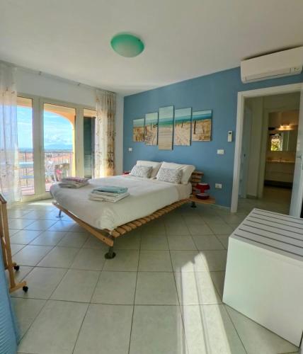 a bedroom with a bed and a blue wall at Modern Seaview Townhouse - Workcation friendly in Orosei