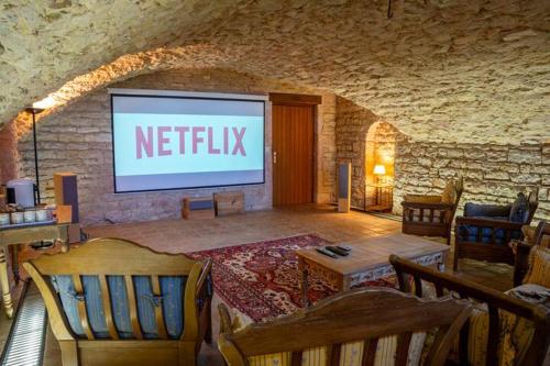 a theatre with a screen in a stone wall at Le Moulin , Cinema , Terrain Tennis BY PRIMO C0NCIERGERIE in Cuisery