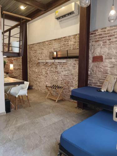 ein Zimmer mit einer Ziegelwand und blauen Betten in der Unterkunft Hermoso apartamento con patio privado in Cartagena de Indias
