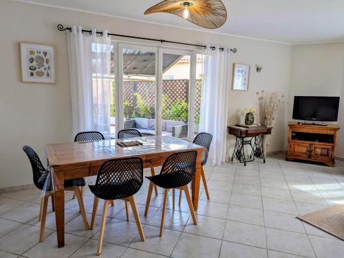 une salle à manger avec une table et des chaises en bois dans l'établissement Spacieux 4 pièces entièrement climatisé, à Vallauris