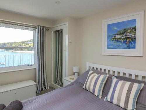 a bedroom with a bed and a large window at 37 The Salcombe in Salcombe