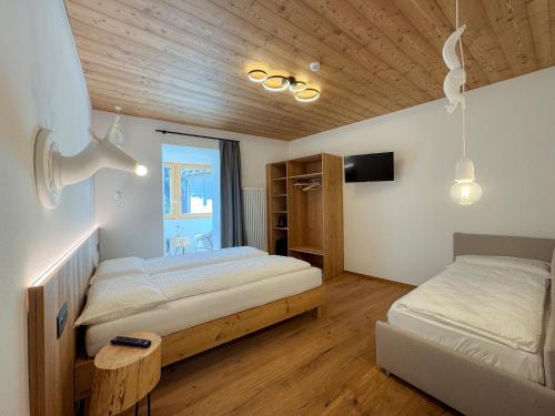 a bedroom with two beds and a tv in it at La Stua in Vermiglio