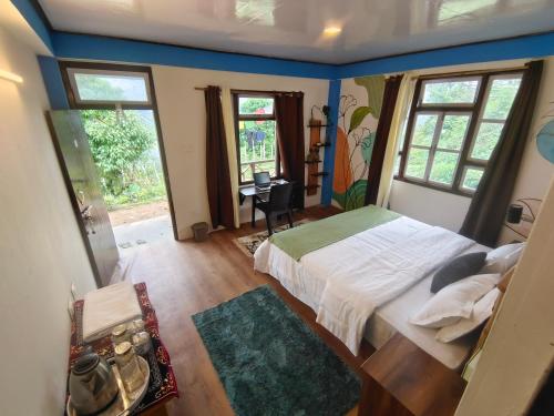 a bedroom with a bed and two windows at The Blue House in Pelling