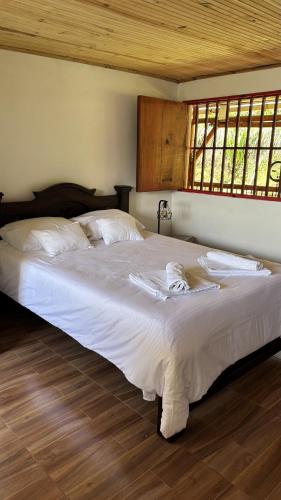 a large white bed in a room with windows at Finca La Macarena by Welttisch in Génova