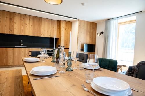 a dining room with a wooden table with plates and wine glasses at La Stua in Vermiglio