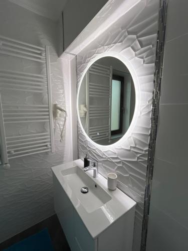 a bathroom with a white sink and a mirror at Azur Villa in Balatonalmádi