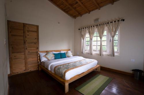 una camera da letto con un letto e due finestre di Eco Village Life Ramgarh a Rāmgarh