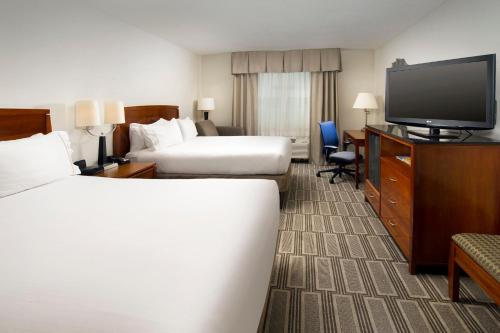 a hotel room with two beds and a flat screen tv at Holiday Inn Express Baltimore At The Stadiums by IHG in Baltimore