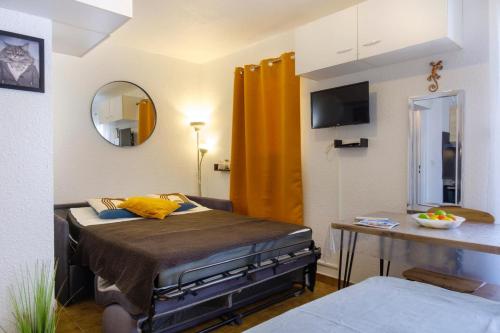 une petite chambre avec un lit et un miroir dans l'établissement Studio with balcony 50 m from the beach, à Sainte-Maxime