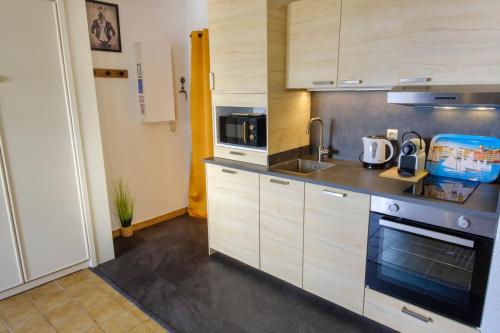 une cuisine avec un évier et une cuisinière four supérieur dans l'établissement Studio with balcony 50 m from the beach, à Sainte-Maxime