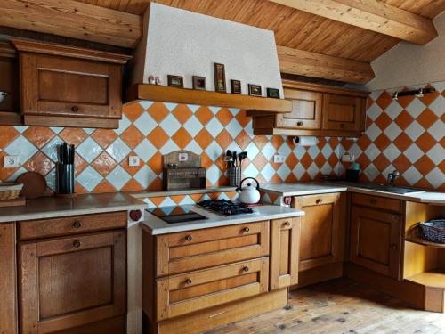 a kitchen with wooden cabinets and a stove top oven at Beauregard Jura - Countryside Estate Stays Near Geneva in Gex