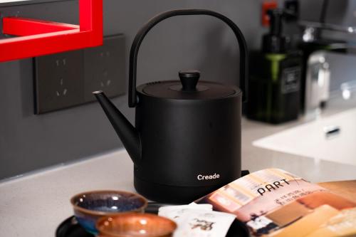 a black tea kettle sitting on a kitchen counter at Xiamen Zhongshan Road Pedestrian Street Qulistar Hotel in Xiamen