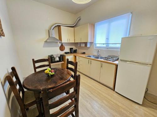 a kitchen with a table and a white refrigerator at Fiori Sea View Apartment in Pyrgi