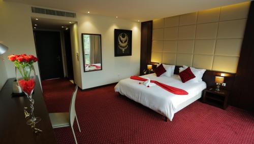 a hotel room with a white bed with red pillows at GHS Hotel in Brazzaville