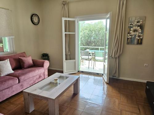 a living room with a pink couch and a table at Fiori Sea View Apartment in Pyrgi