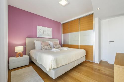 ein Schlafzimmer mit einem weißen Bett und einer lila Wand in der Unterkunft Forum Ocean View 5C by Homie in Ilhéu do Gorgulho