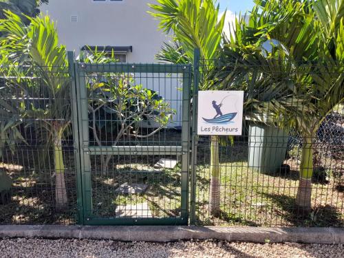 a sign on a fence with a sign on it at Les Pêcheurs in Le Morne