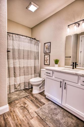 a bathroom with a toilet and a sink and a mirror at Vacation Together at Our 2 Condos Providing 6 Bedroom Suites in Osage Beach