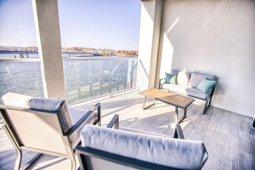 a balcony with chairs and a view of the water at Vacation Together at Our 2 Condos Providing 6 Bedroom Suites in Osage Beach