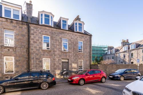 a group of cars parked in front of a brick building at Heart of Aberdeen * Ground Floor in Aberdeen