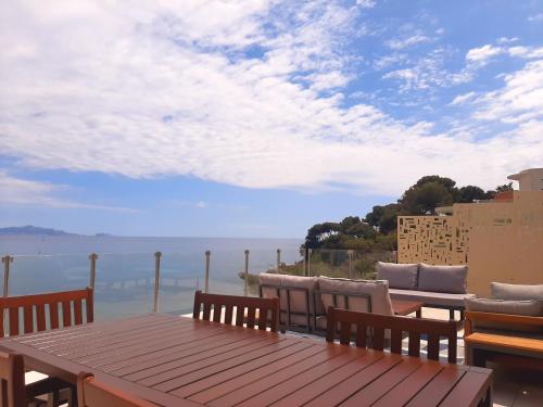 une table et des chaises sur un balcon avec vue sur l'océan dans l'établissement Villa de charme - Panorama Exceptionnel et Accès direct Mer, à Carry-le-Rouet