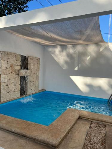 a swimming pool in a house with a water feature at Casa Coco in Valladolid