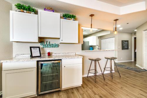 a kitchen with white cabinets and bar stools at Waterfront Lake Ozark Condo with Pool Access in Lake Ozark