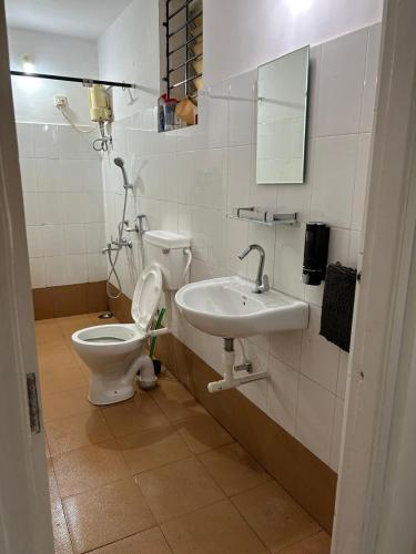 a bathroom with a toilet and a sink at Palms Cosy affordable homely flat in Arpora