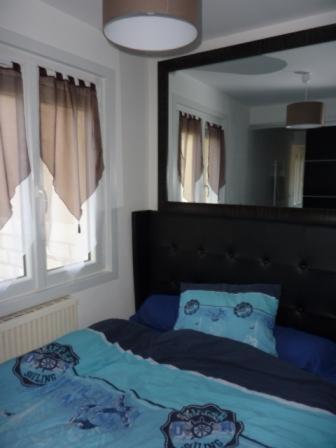 - une chambre avec un grand miroir au-dessus d'un lit dans l'établissement Appartement front de mer Biarritz, à Biarritz