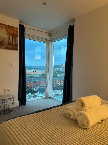 a bedroom with a bed with a large window at Marina Breeze in Swansea