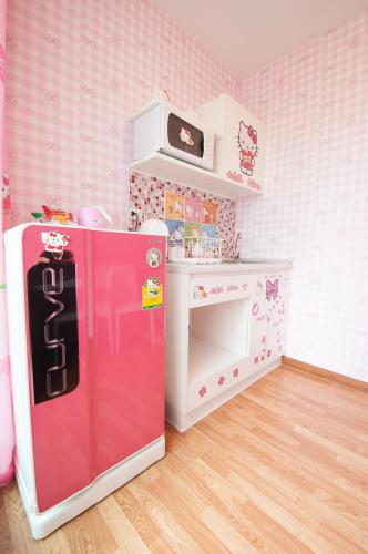 a childs room with a refrigerator and a table at The Trust Hua Hin kitty room in Hua Hin