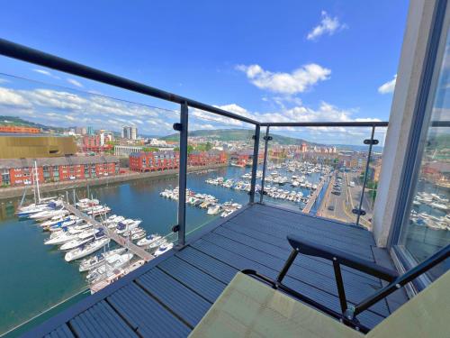 a balcony with a view of a marina with boats at Marina Breeze in Swansea