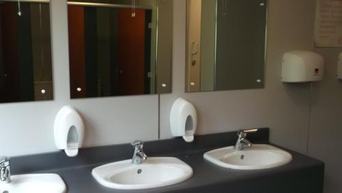 a bathroom with three sinks and three mirrors at Crianlarich Youth Hostel in Crianlarich