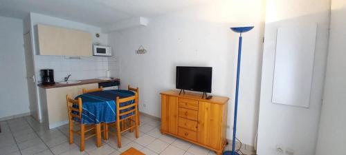 - une petite cuisine avec une table et une télévision dans la chambre dans l'établissement Joli pavillon pour 6 personnes a 50m de la plage, à Valras-Plage