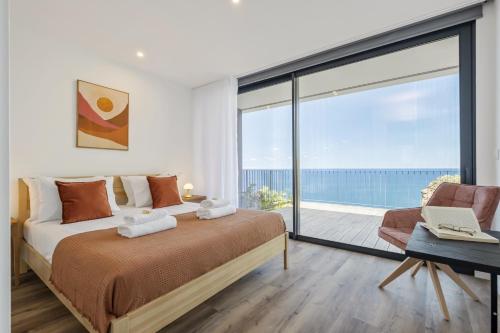 a bedroom with a large bed and a large window at Atlantic Gem by Homie in Câmara de Lobos