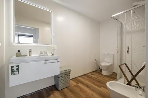 une salle de bains blanche avec un lavabo et un miroir dans l'établissement Atlantic Gem by Homie, à Câmara de Lobos