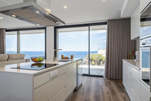 a kitchen with a view of the ocean at Atlantic Gem by Homie in Câmara de Lobos